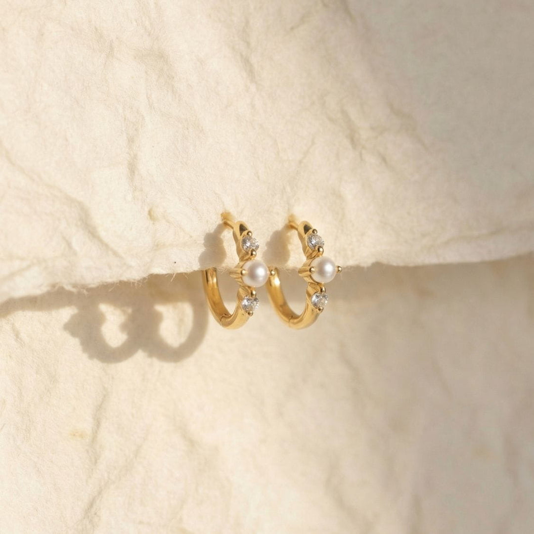 Vivek Gold Pearl Huggie Earrings Hanging on Paper